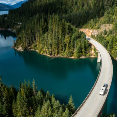 Aerial view of an RV crossing a bridge over a lake.